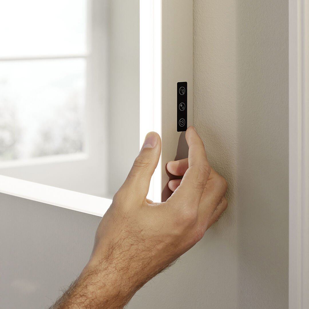 hand dr&uuml;ckt auf dimmer seitlich von spiegelschrank