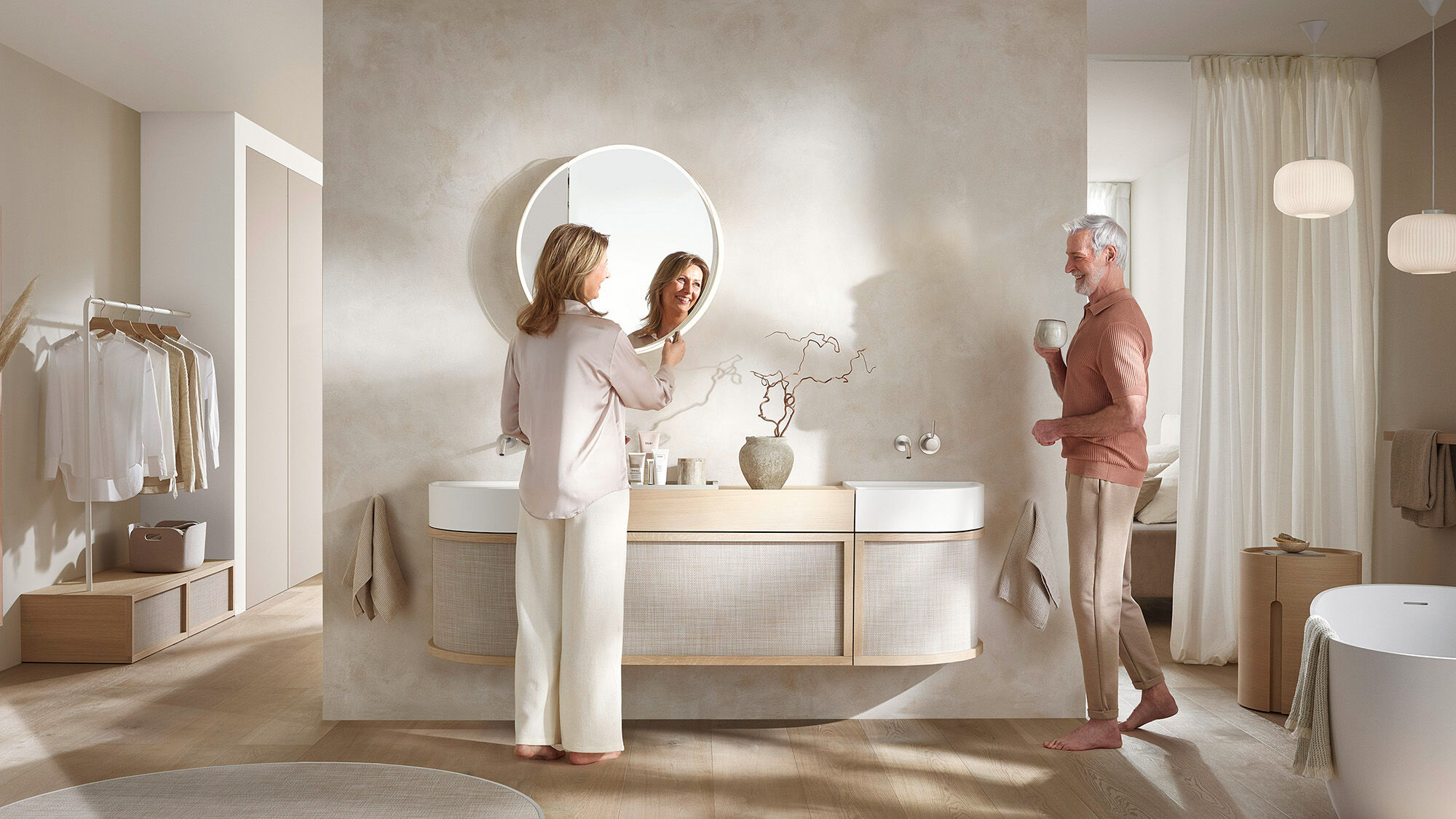 frau schaut in runden badspiegel in beigem modernem bad