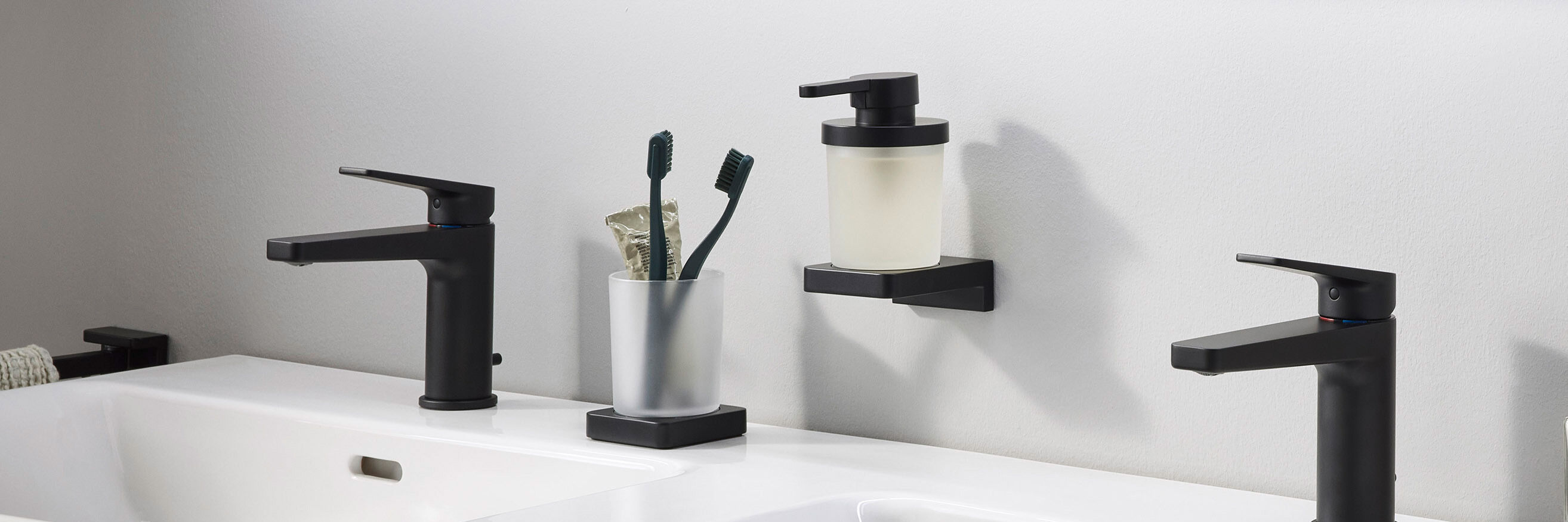 schwarz-matt zahnglas und seifenspender neben schwarzen armaturen
