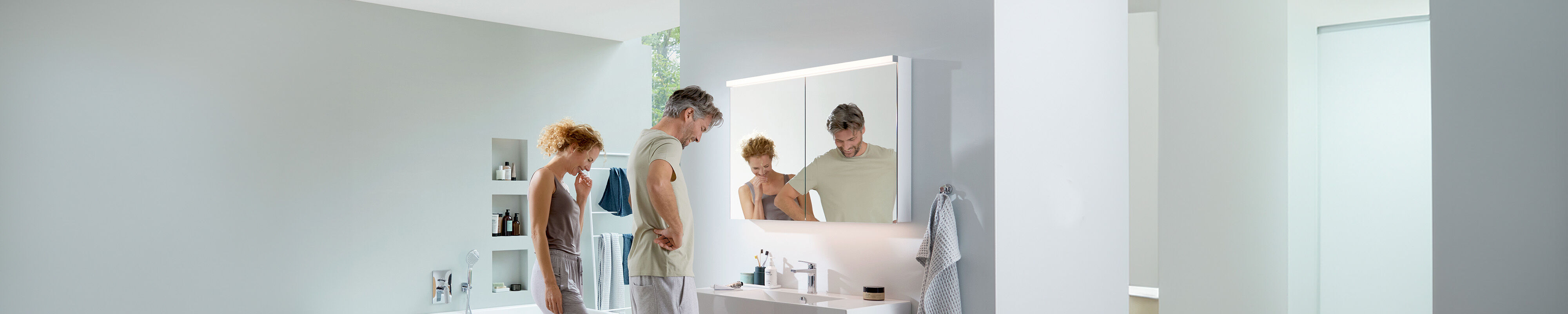 frau und mann stehen vor alterna karat led spiegelschrank