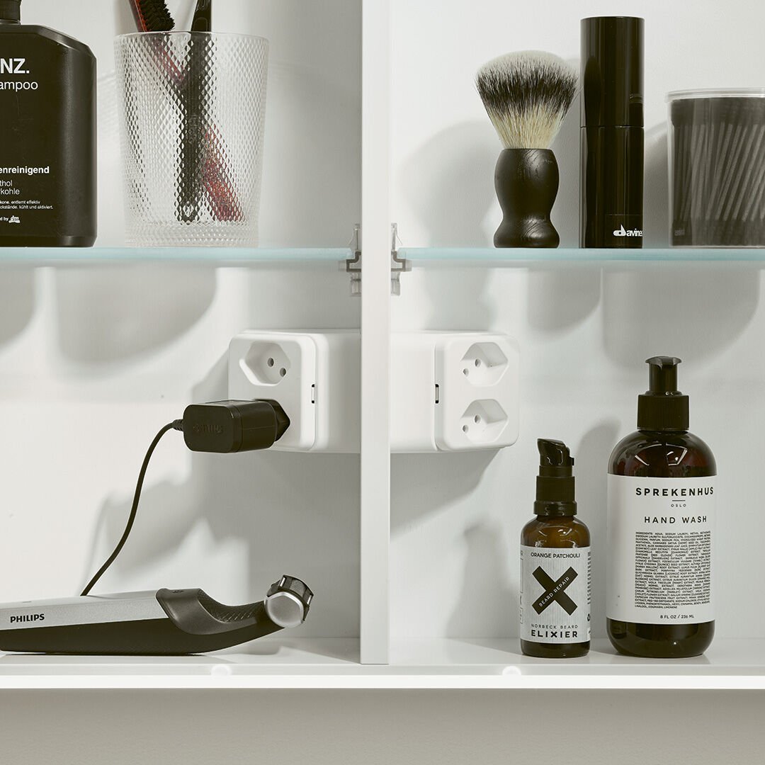 spiegelschrank offen mit steckdosen und seife und pflegeprodukten